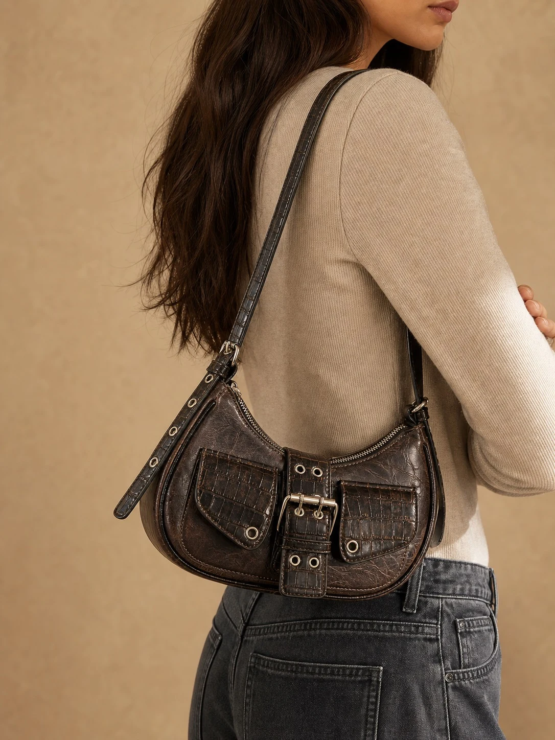 Distressed brown Y2K motorcycle bag worn on shoulder with denim styling