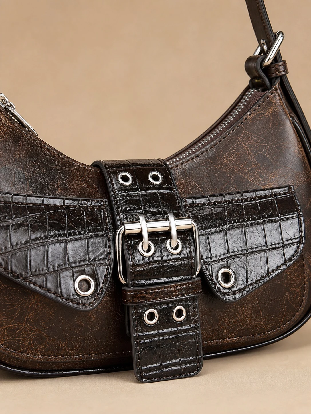 Close up of distressed brown texture croc embossed pocket and silver buckle hardware