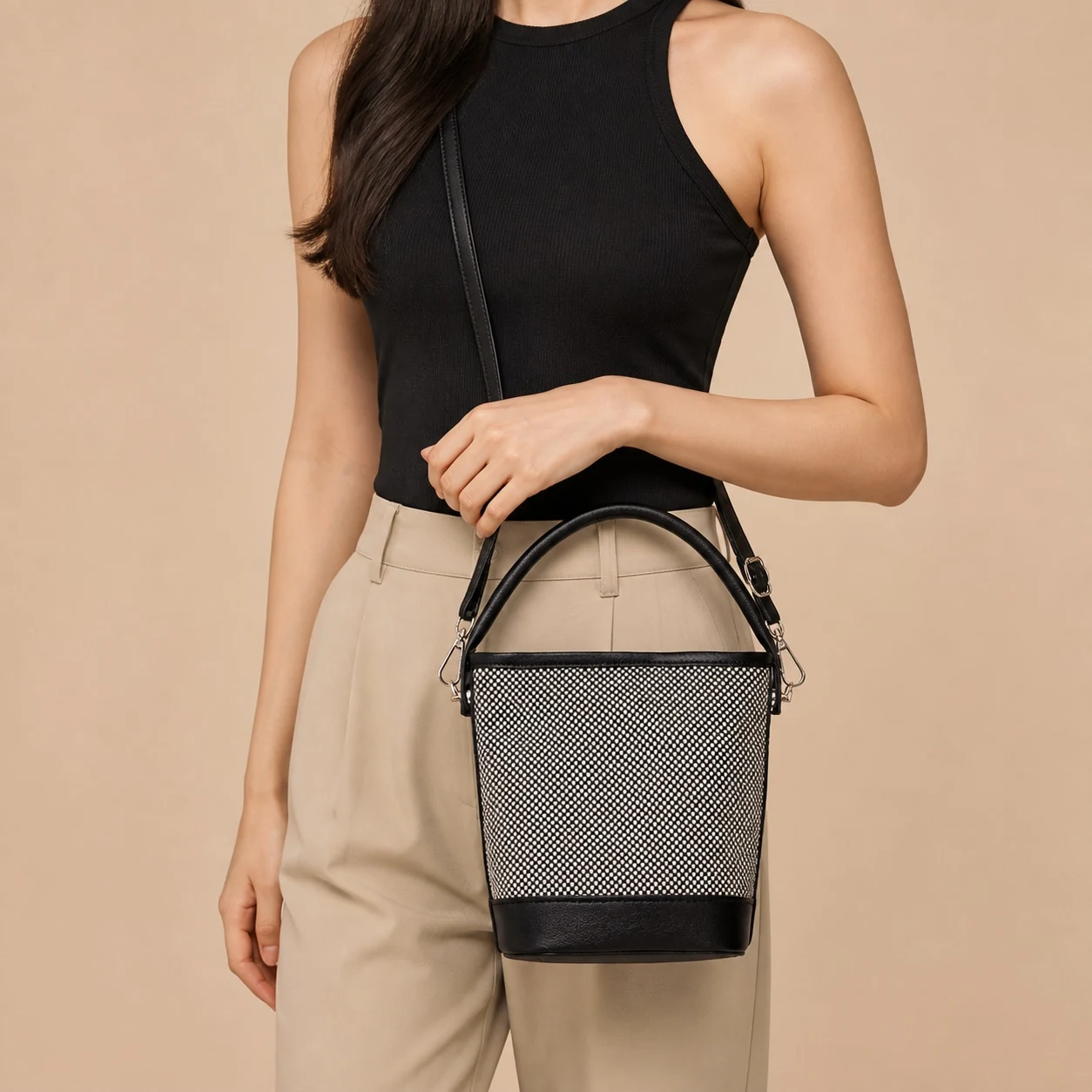 Black and white woven bucket bag carried by hand